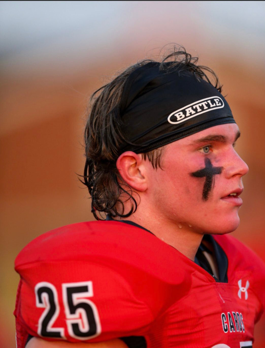 Football player wearing a Black fabric Battle Skull Wrap with the word battle written on it in white