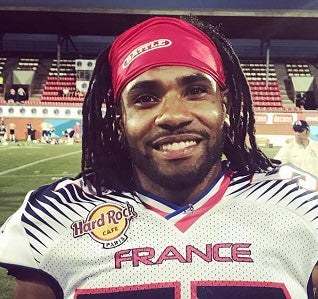 a smiling football player wearing a red fabric Battle Skull Wrap with the word battle written on it in white